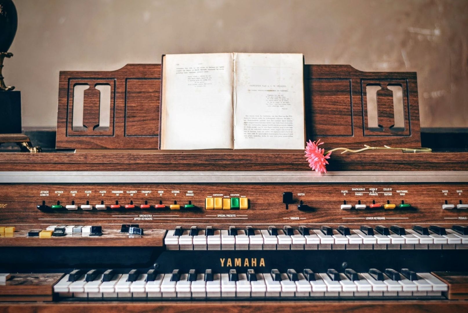 Vintage-Hammondorgel mit zwei Tastaturen, Reglern, Notenbuch und Blume
